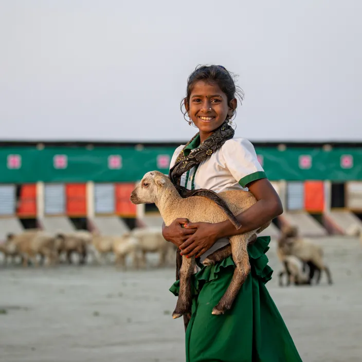 girl carrying baby goat