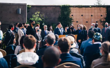 man speaking to crowd outside